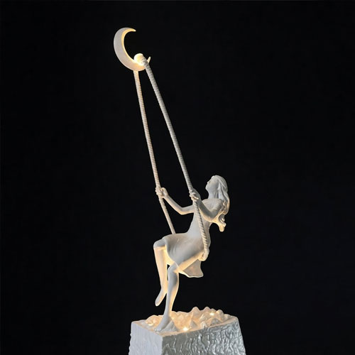 Marble statue of a girl posing while on a swing